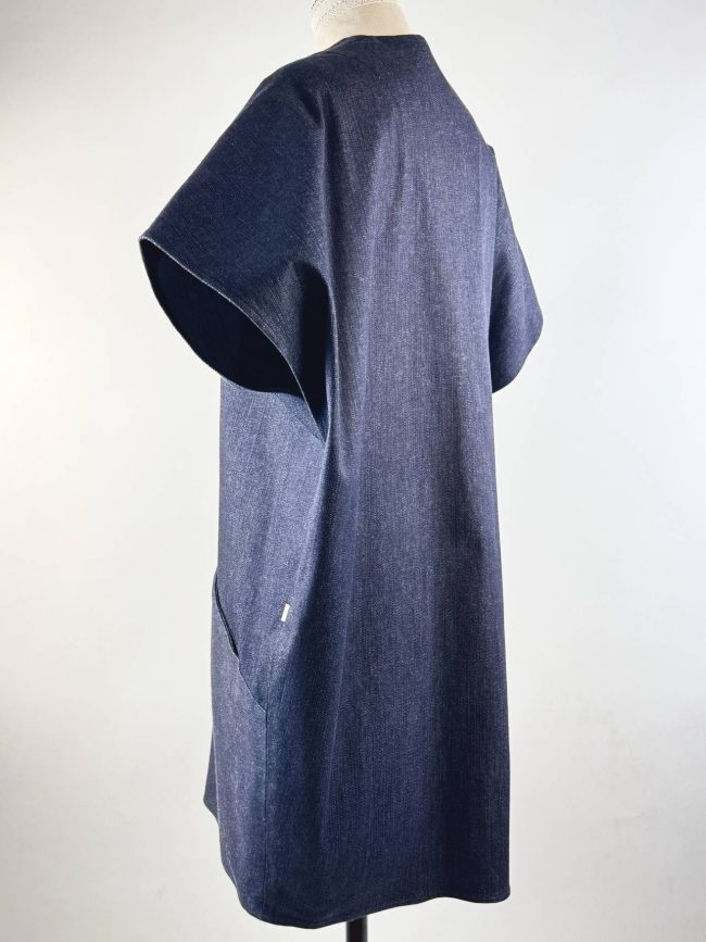 Robe ample sans manches en jean bleu marine, col en V, coupe trapèze fluide et contemporaine. vue 3/4 dos