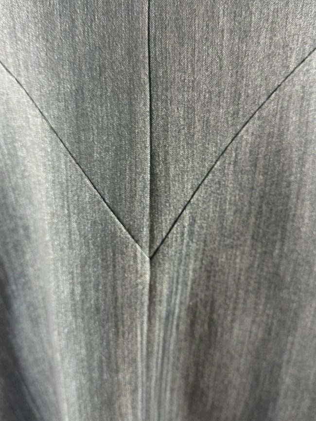Robe trapèze sans manches en tissu effet jean noir, col en V, avec deux grandes poches plaquées. Detail dos